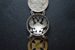A 1915 COMMEMORATIVE CROSS & BONES WATCH FOB.
